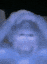 a blurred image of a person 's face with a purple background