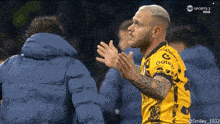 a soccer player wearing a yellow jersey that says gatec
