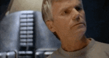 a close up of a man 's face with a blurred background of a machine .