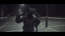 a man wearing a black puma sweatshirt is standing next to another man