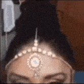 a close up of a woman 's face with a headpiece on her forehead .