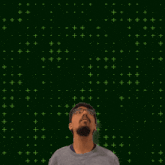 a man with glasses stands in front of a green background with the number 10 and 3