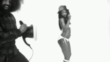 a black and white photo of a man holding a megaphone and a woman dancing .