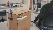 a cardboard box with three ultrasonic sensors attached to it sits on a desk