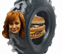 a woman 's head is sticking out of a tire with a hamburger inside .
