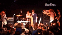 a group of people playing instruments in front of a crowd with the words beatcast.tv on the bottom right