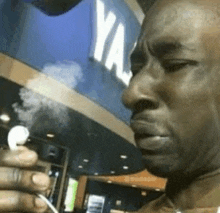 a man is smoking a pipe in front of a ya 's restaurant .