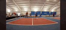 a group of people are playing tennis in a gym