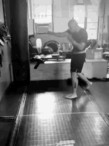 a man with a tattoo on his leg is boxing in a gym