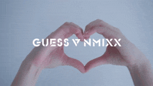 a woman making a heart shape with her hands with the words guess v nmixx visible