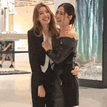 two women are posing for a picture and one of them is wearing a leather jacket