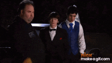 a group of men are standing in front of a car with a nick id make a gif.com watermark