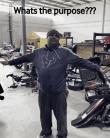 a man with his arms outstretched in a garage with the words whats the purpose on the bottom