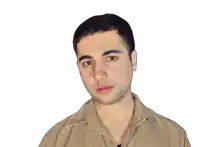 a man wearing a tan shirt with a collar looks at the camera