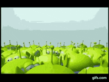 a bunch of green aliens from toy story are standing in a field .