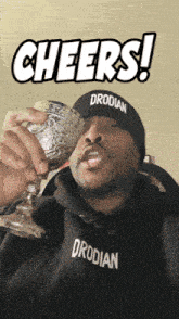 a man wearing a drodilan hat holds a glass of wine