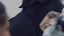 a close up of a woman wearing a hijab looking down
