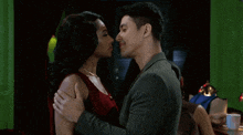 a man and a woman are looking at each other in a dark room