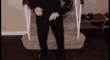 a man is standing on a set of stairs with his hands on his knees .