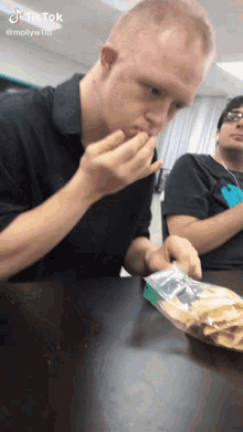 a man sitting at a table with a bag of chips in front of him with a tiktok watermark