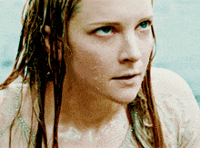 a close up of a woman 's face with water drops on her face