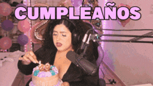 a woman wearing headphones is cutting a birthday cake with the words cumpleanos in the background