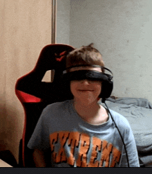 a young boy wearing headphones and a shirt that says extreme on it