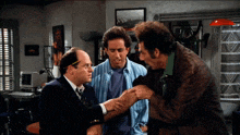 three men are standing in a room and one of them is holding the arm of another man