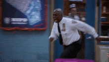 a man in a white shirt and black pants is running in a doorway