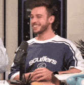 a man wearing a shirt that says scuffers on it