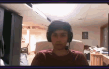 a man wearing headphones is sitting in a chair in a room .