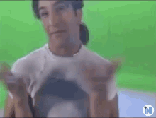 a man in a white shirt is standing in front of a green screen with the letter n on it .