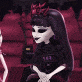 a monster high doll with a crown on her head sits next to another doll