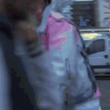 a blurry picture of a person wearing a pink and white jacket