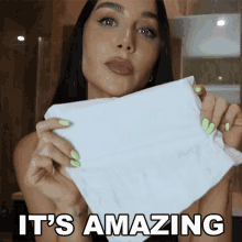 a woman is holding a piece of paper that says it 's amazing on it