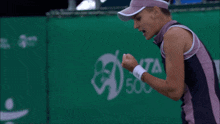 a woman in a pink visor stands in front of a banner that says ita 500