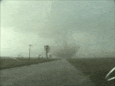a view of a tornado coming down a road