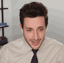 a man with a beard wearing a white shirt and blue tie