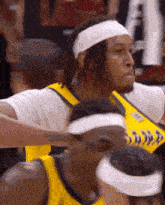 a basketball player wearing a headband and a yellow jersey