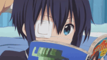 a person with a bandage on their eye is reading a book with the letter l on it