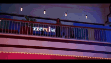 a woman stands on a balcony with a sign that says exercise on it