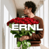 a man is holding a large bouquet of red roses with the word ernl behind him