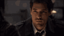 a man in a suit and tie is smiling and looking at the camera
