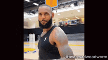 a man with a beard is standing in front of a gym that says ucla on the wall