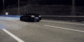 a black car is driving down a highway at night with a license plate that says ' a '