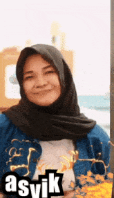 a woman wearing a black scarf and a denim jacket with the name asvik on the bottom right