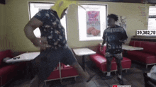two men are dancing in a diner with a sign that says chicken & waffles on it
