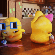 two yellow ducks wearing sunglasses are standing next to each other on a kitchen floor