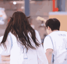 a man and a woman are holding hands and the man is wearing a jersey with the number 7 on it