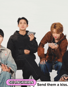 seungkwan is sitting in the middle of a group of young men